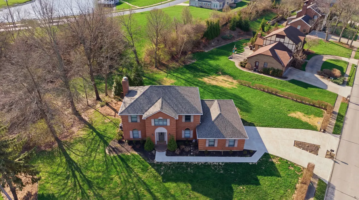Aerial view of a brick two story home with a new grey shingle roof
