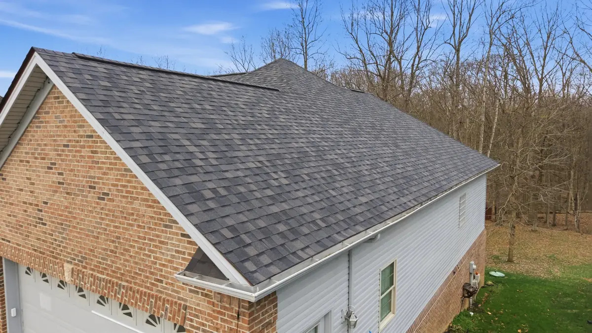 Low aerial of a brick and siding ranch with a new dark grey shingle roof